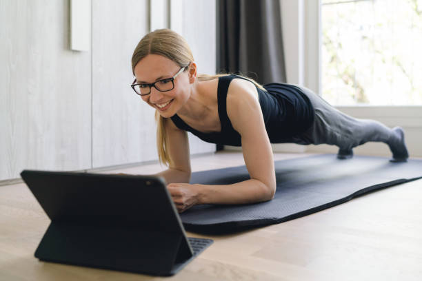Plank exercise at home with tablet stock photo