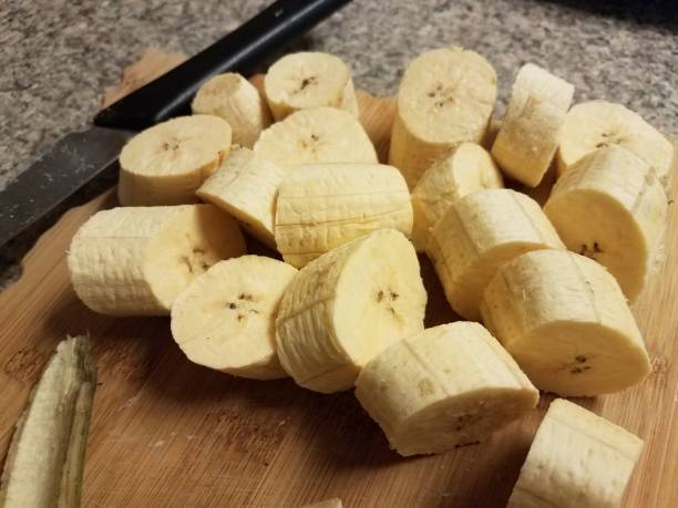 plantain banana and knife on wood cutting board stock photo