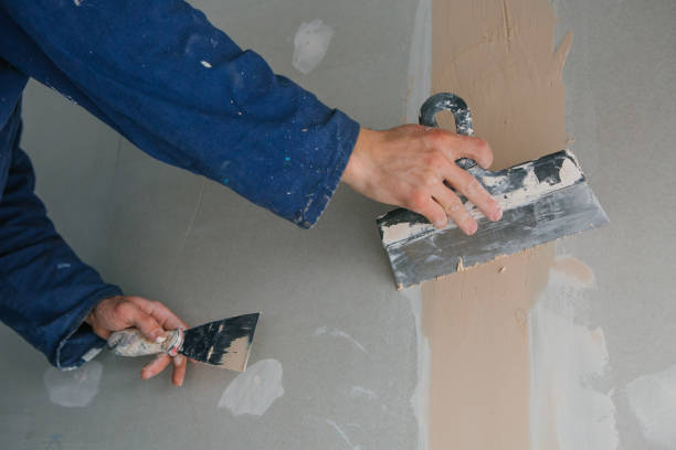 plasterer works plastering two trowels plasterboard blue uniform stock photo