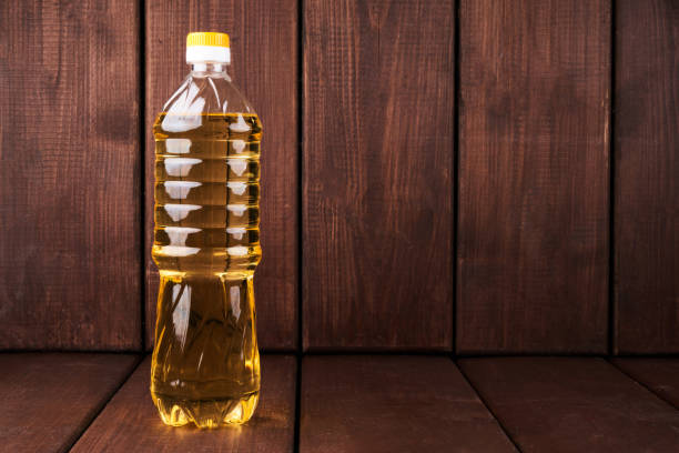 Plastic bottle of vegetable sunflower olive oil isolated on wooden kitchen background stock photo