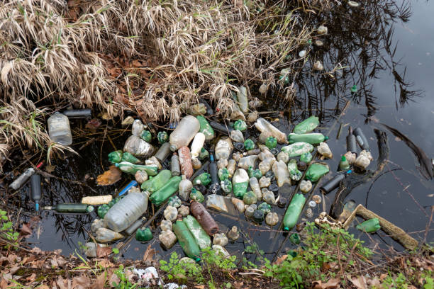 Plastic bottles and trash in a polluted river. Water contamination stock photo