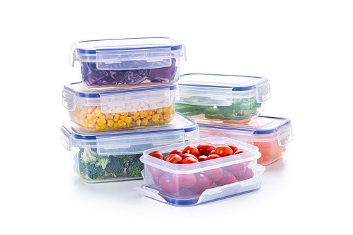 Front view of a group of various plastic containers isolated on white background, Each container is filled with a different vegetable. Studio shot taken with Canon EOS 6D Mark II and Canon EF 100 mm f/ 2.8
