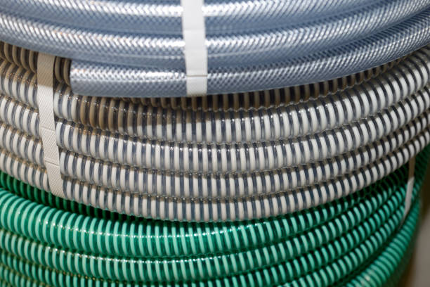 Plastic corrugated tubes for water supply, rolled up Green, gray, blue plastic corrugated tubes for water supply, rolled up. Shallow depth of field hose stock pictures, royalty-free photos & images