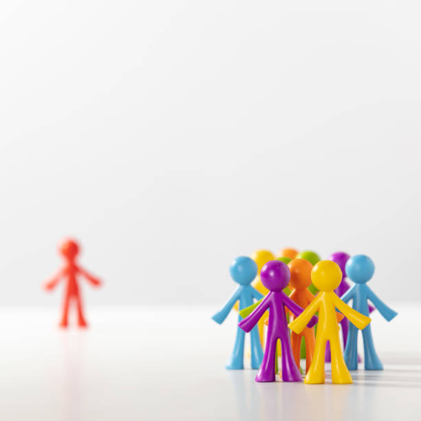Plastic figures - crowd of people and a lonely figure of a different color stock photo
