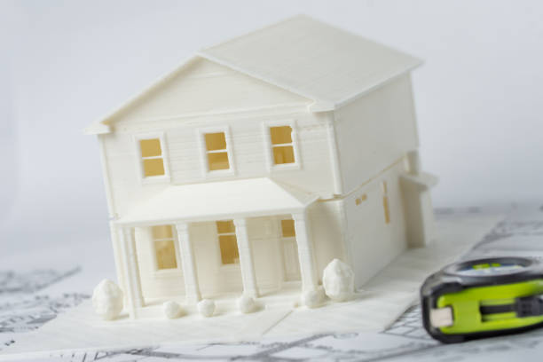 3D plastic model of the family house printed on a 3D printer for architectural use and measuring tape in foreground. stock photo