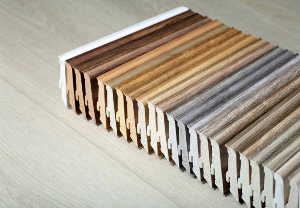 Plastic skirting board with wood texture in various colors. Design and production of flooring and molded for flooring. Skirting board for interior design of living rooms and houses stock photo