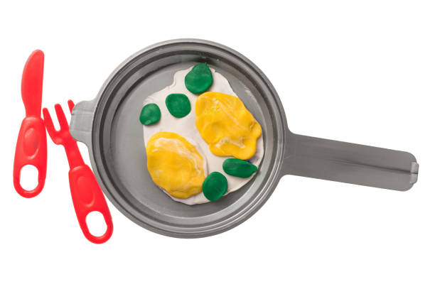 plasticine fried eggs in a pan stock photo