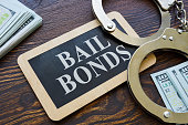 istock Plate Bail bonds and handcuffs on it. 1334477288