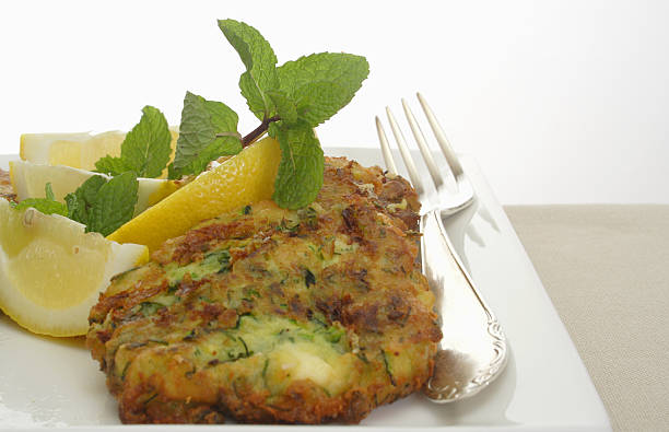 plate of fresh zuchini fritters with fork stock photo