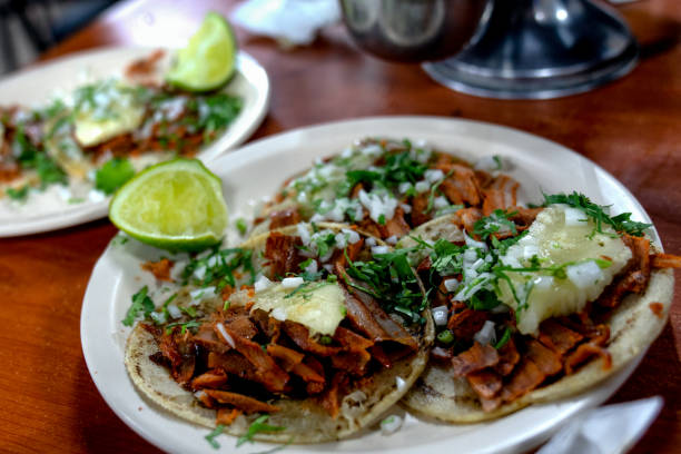 A Plate Of Tacos Al Pastor, Corn Tortillas, Shaved Pork, Sauce, Sliced Pineapple, Cilantro,Cheese And Lime A beautiful and delicious meal of Tacos Al Pastor in Puerto Vallarta Mexico puerto vallarta stock pictures, royalty-free photos & images