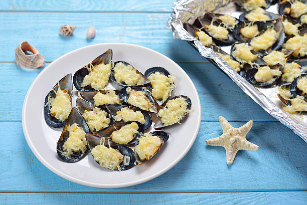 Plate with baked mussels with cheese stock photo
