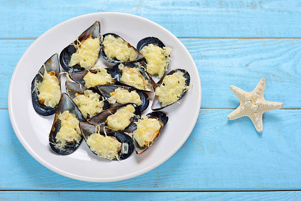 Plate with baked mussels with cheese stock photo