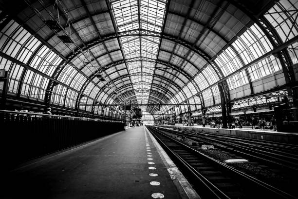 Platforms of the Amsterdam train station (Amsterdam Central Station - Centraal Station), Netherlands. Black and white image. Low key image Platforms of the Amsterdam train station (Amsterdam Central Station - Centraal Station), Netherlands. Black and white image. Low key image railroad station photos stock pictures, royalty-free photos & images