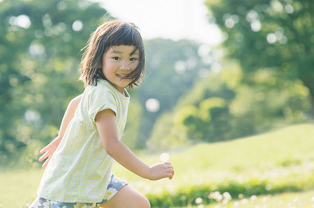 自然の中で楽しい時間を持っている遊び心のある女の子 - 子供時代 ストックフォトと画像