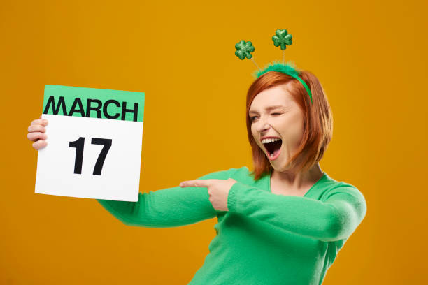 Playful woman pointing at Saint Patrick's Day calendar Playful woman pointing at Saint Patrick's Day calendar irish women stock pictures, royalty-free photos & images