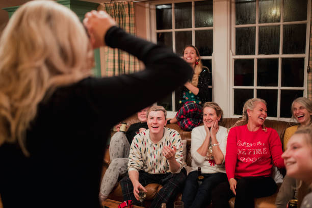 Playing a Modern Guessing Game at Christmas Group of friends and family are playing a modern guessing game with a smartphone at christmas. charades stock pictures, royalty-free photos & images