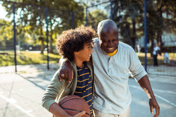 a boy playing basketball with his dad