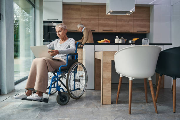 Pleased disabled woman working at her computer stock photo