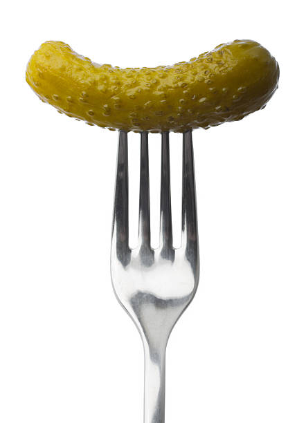 Plot Pickled gherkin on fork isolated on white pickle stock pictures, royalty-free photos & images