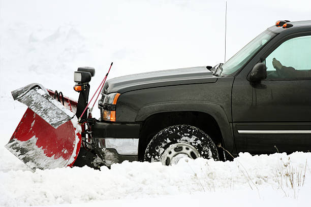 plow  removing snow on cold stormy day stock photo
