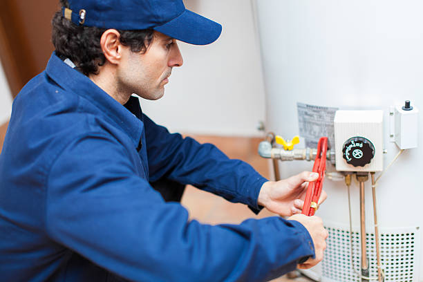 plumber fixing an hot-water heater - boiler stockfoto's en -beelden