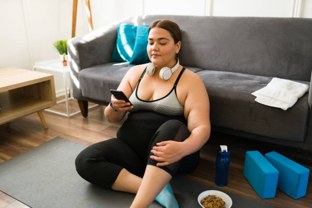 Plus size woman using a fitness app stock photo