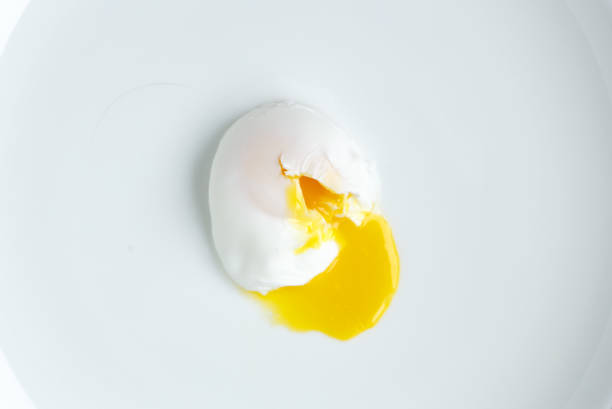 poached egg closeup shot on white background stock photo