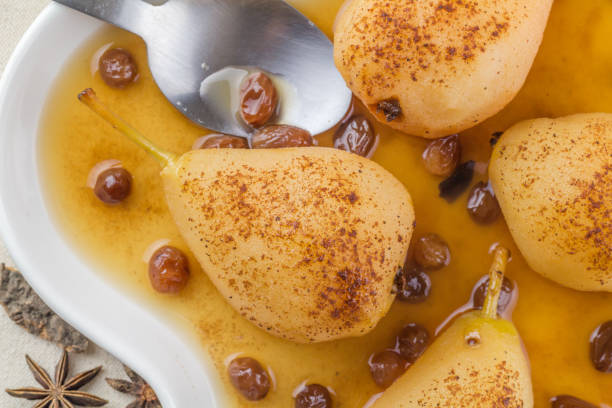 Poached spice pears in vanilla raisin syrup - top view close up photo stock photo