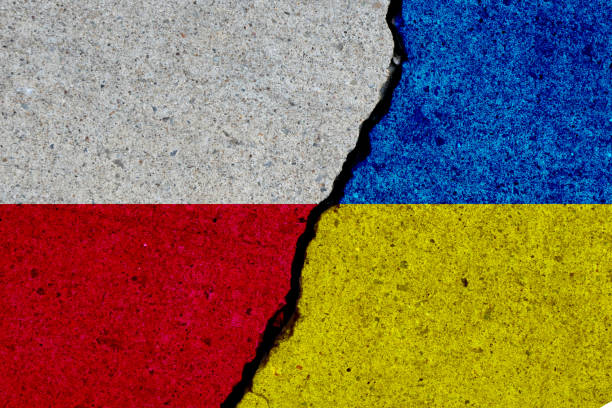 poland and ukraine flags painted over cracked concrete wall stock photo