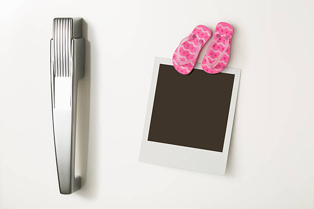 Polaroid print with flip-flop fridge magnet on refrigerator door stock photo