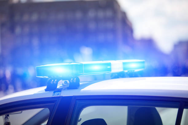 Police car with blue lights on the crime scene in traffic urban environment. stock photo
