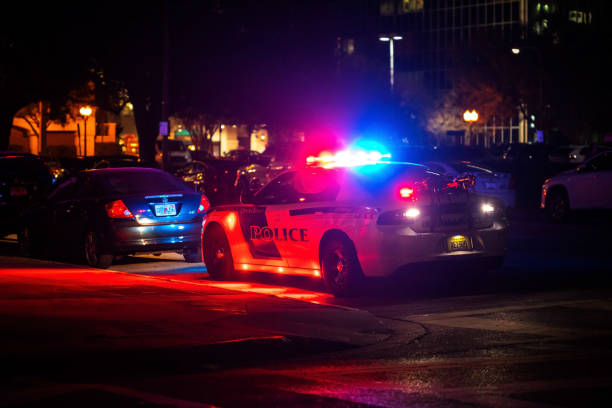 Police car with emergency lights flashing at night in city stock photo