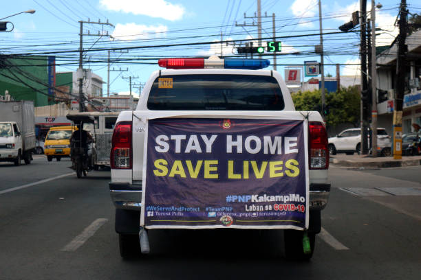 Police car with signage to stay at home patrols the streets during the Covid 19 virus outbreak stock photo