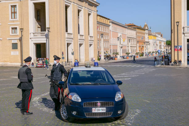 eine italienische polizeistreife mit medizinischer maske kontrolliert den zugang zum platz des petersdoms - italienisches militär stock-fotos und bilder