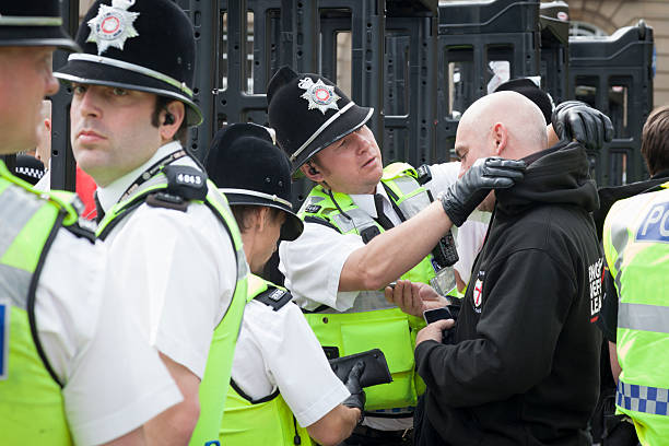 Police search a man at the English Defence League rally stock photo