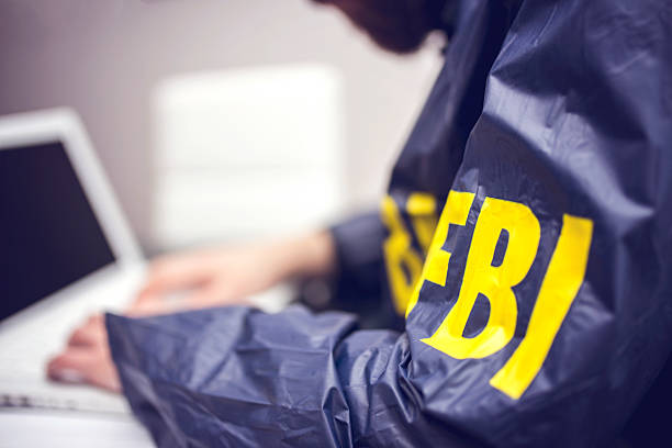 policeman using laptop in office - fbi stok fotoğraflar ve resimler