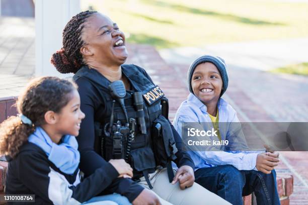 Policewoman in the community, sitting with two children