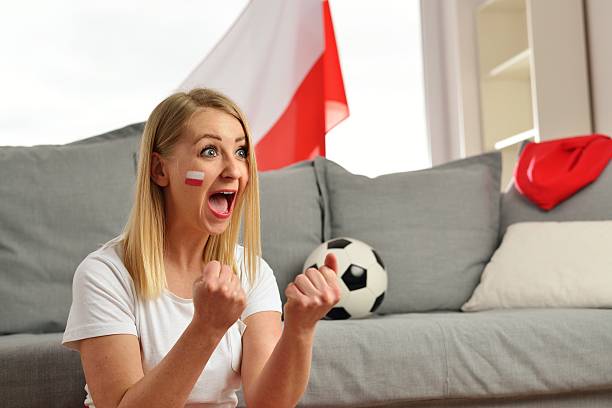 Polish fan cheers football team in the national colors. stock photo