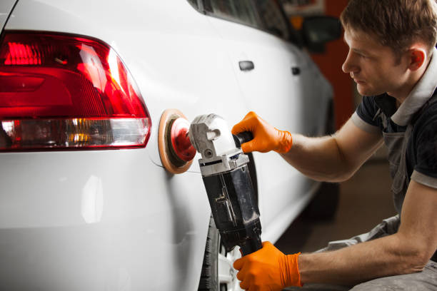 Polishing white car, close-up. A man polishes the automobile from scratches. Polishing white car, close-up. A man polishes the automobile from scratches. Worker at garage. lacquered stock pictures, royalty-free photos & images