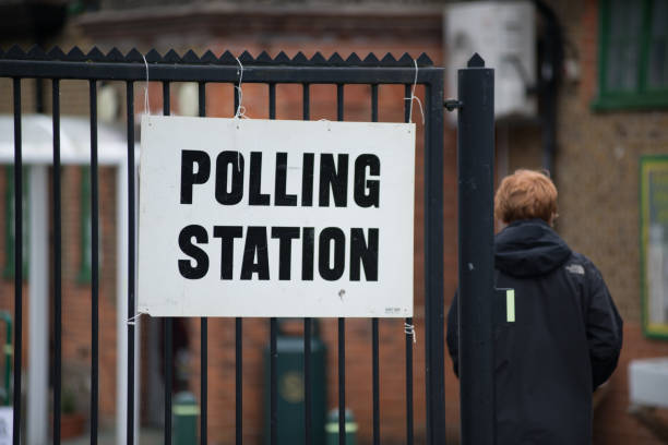 Polling station sign Welwyn Garden City, UK - June 8, 2017: Polling station sings during an election in the UK. A man can be seen entering the polling station was in Welwyn Garden City during the UK 8 June 2017 election. polling place stock pictures, royalty-free photos & images