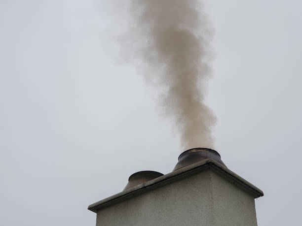 Polluting smoke from chimney in dirty environment stock photo
