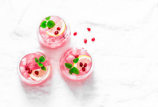 Pomegranate tequila cocktail. Summer light alcoholic drink,  cooling aperitif. On light background, top view, free space. Flat lay Pomegranate tequila cocktail. Summer light alcoholic drink,  cooling aperitif. On light background, top view, free space. Flat lay cold drink photos stock pictures, royalty-free photos & images
