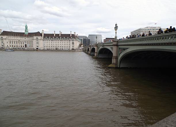 Ponte di Westminster London, England - May 20, 2016: The Westminster Bridge seen from the subway exit. The bridge was built in 1862 in iron with seven arches decorated in neo-Gothic style. Watching the big building that houses the aquarium, the Sea Life London Aquarium, the Museum of the horrible story, the London Dungeon, and Shrek's Adventure theme park museum di london stock pictures, royalty-free photos & images