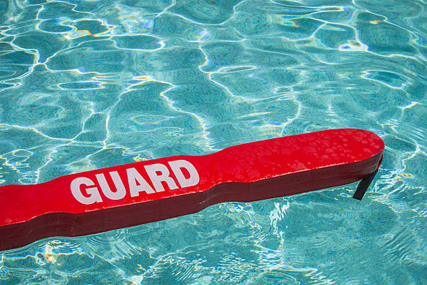 Pool Safe A close up shot of a life guards red rescue tube floating in a pool. lifeguard stock pictures, royalty-free photos & images