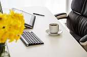 istock Pop of color with yellow daffodils on a office desk 1371339332