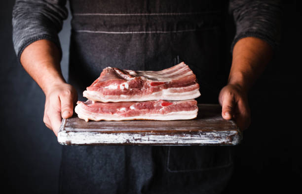 Pork belly porchetta Farm fresh Pork Belly butcher person curring bacon porchetta pork stock pictures, royalty-free photos & images