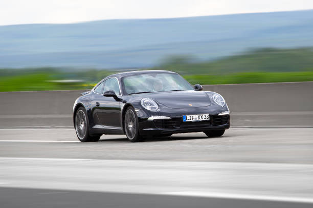 Porsche 911 (992) Weilbach, Germany - May 12, 2021: A Porsche 911 (992) on a highway nearby Wiesbaden, Germany. Porsche is a car manufacturer of luxury high performance cars based in Stuttgart, Germany and founded in 1931. porsche 911 stock pictures, royalty-free photos & images
