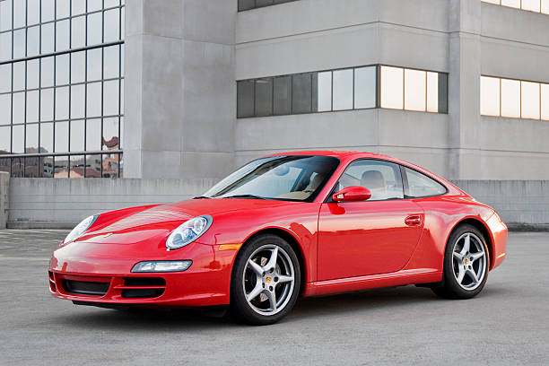 Porsche 911 "Nashville, Tennessee, USA - August, 30th 2007: A red, model year 2007, 997 generation Porsche 911 Carrera on top of a parking garage at sunset." porsche 911 stock pictures, royalty-free photos & images