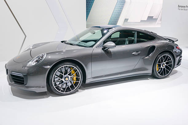 Porsche 911 Turbo S sports car Brussels, Belgium - Januari 12, 2016: Gray Porsche 911 Turbo S sports car front view. The car is on display during the 2016 Brussels Motor Show. The car is displayed on a motor show stand, with lights reflecting off of the body. porsche 911 stock pictures, royalty-free photos & images