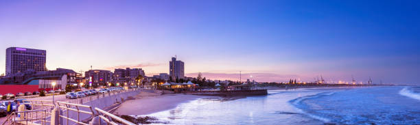 Port Elizabeth panoramic at dusk showing the beachside and docks, with hotels and restaurant entertainment on the left.